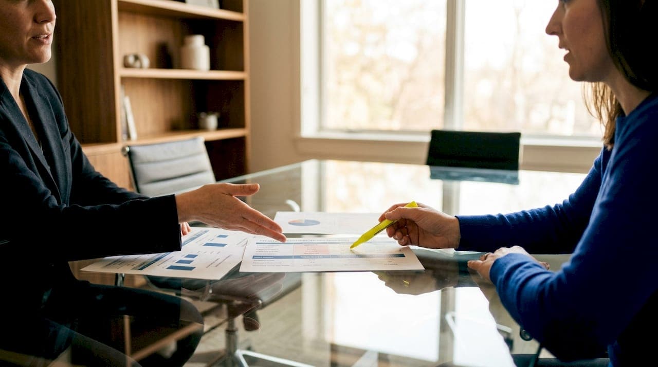 Hands discussing cash sale versus traditional sale charts