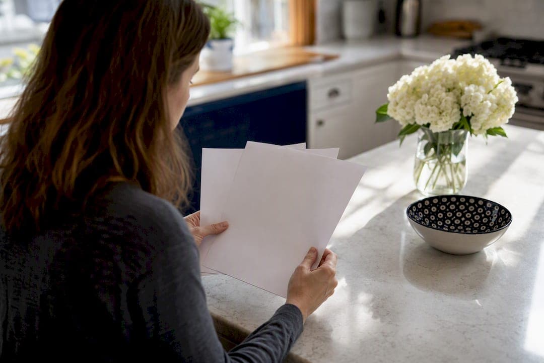 Hands comparing multiple cash offers in living room