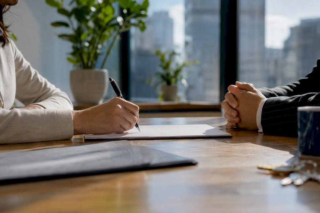 Hands exchanging real estate contract folder