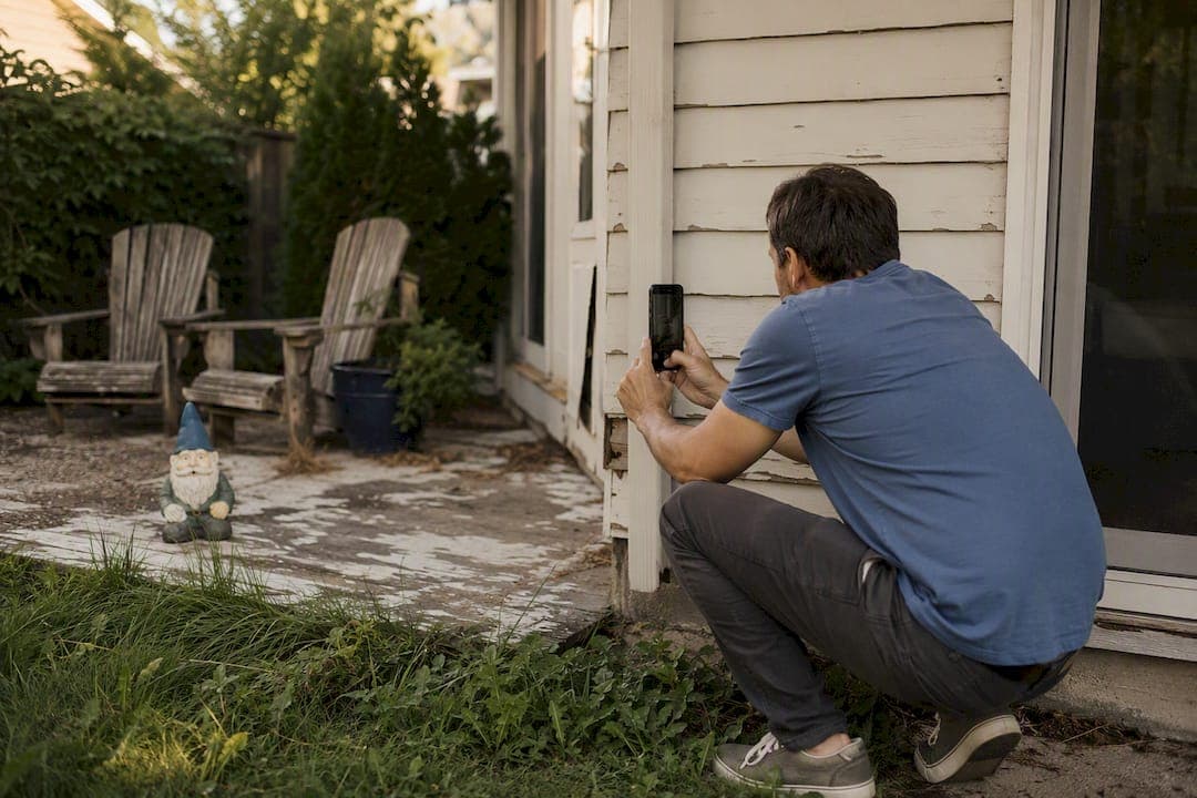 Homeowner photographing house exterior condition