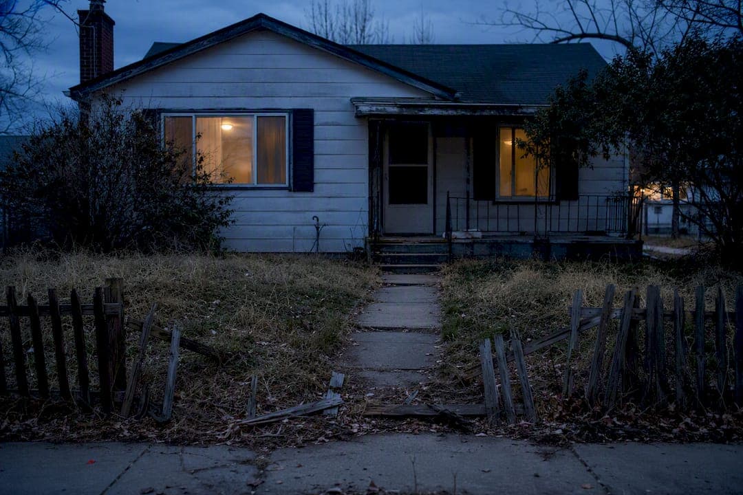 Vacant foreclosed home exterior at sunset